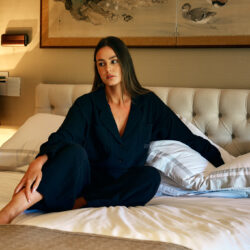Cotone Collection woman on bed in black pyjamas - Quality Sleepwear