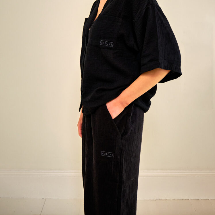 Cotone Collection woman on sofa in black pyjamas - Quality Sleepwear